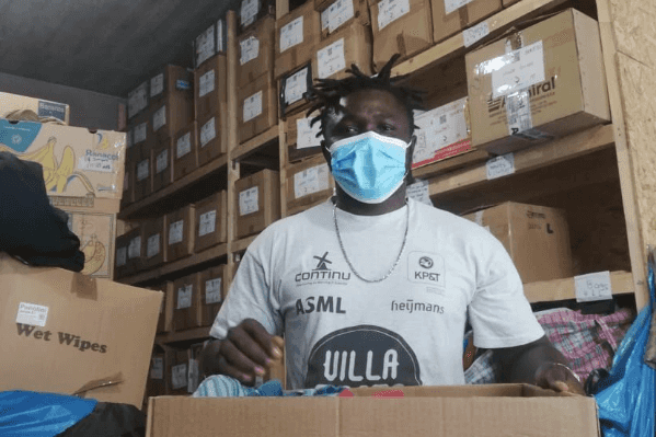 A man sorting through donations of clothes in a warehouse